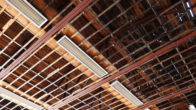 Dolly shot of the ceiling of an abandoned warehouse