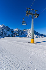 Ski winter season, ski run and chairlift in Italian Alps. Solda with Ortler, Zebru, Grand Zebru in background. Val Venosta, South Tirol, Italy. 