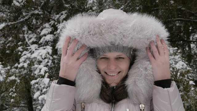Holidays in the Mountains. Young woman wears a hood jacket  in winter, On the hood a lot of snow