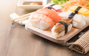 sushi with sauce and wasabi on old brown wood plate