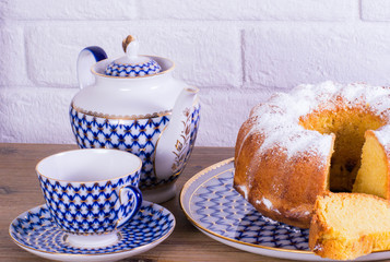 Exposition of apple pie cup of tea and kettle on wooden table and white brick background, Vintage Russian porcelain teacup and kettle.