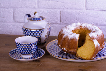 Exposition of apple pie cup of tea and kettle on wooden table and white brick background, Vintage Russian porcelain teacup and kettle.