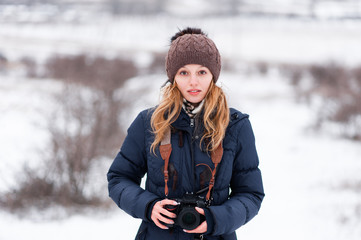 young girl photographer with camera in winter