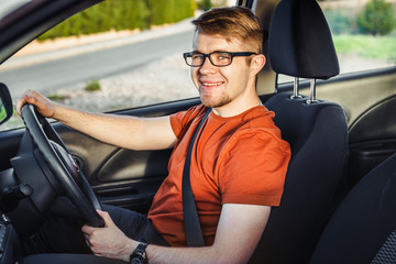 Happy handsome man in his new car