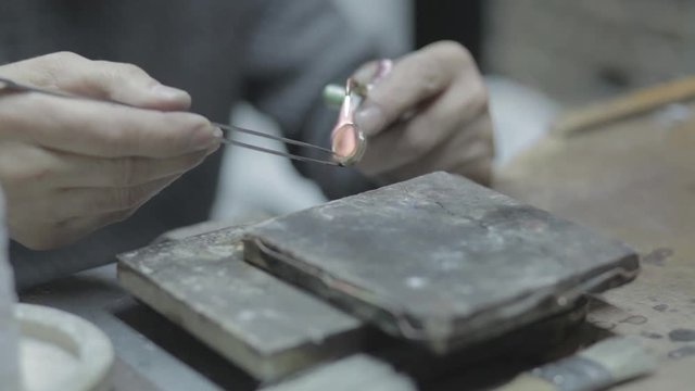 Jewel craft uses blowtorch to make a ring