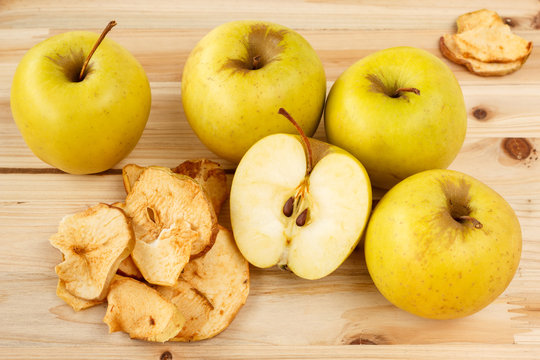 Dried and fresh apples on a wooden background