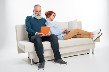 Couple using laptop and digital tablet