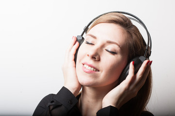 Beautiful smiling woman listening music in headphones