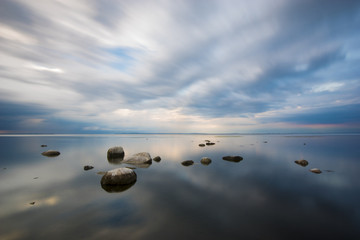 sea landscape at sunrise, boulders on the sea shore