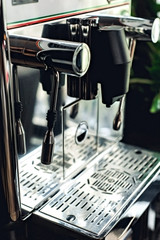 Espresso cappuccino coffee machine on the table with green leaves