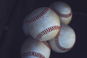Old baseballs in a pile, perfect for sports or athletic background.