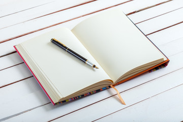 the ink handle lies on empty page of a notebook.