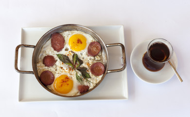 Fried eggs with sausage in pan