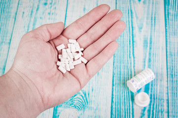 Close-up shot of a hand holding several capsuls pills.