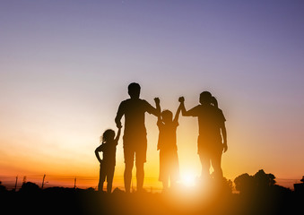 Fototapeta na wymiar Silhouette of father mother and two kids having fun on sunset, Happy family concept.