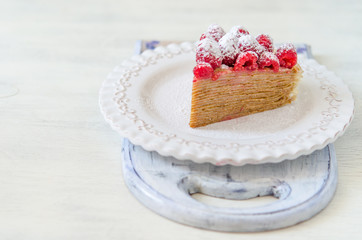Pancake cake with condensed milk cream and raspberries