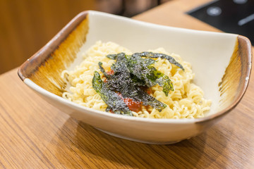 Dry Japanese noodles (Ramen) with sauce and Dry roasted seaweed on top for cooking.