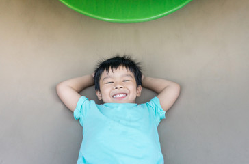 Asian boy playing inside a tunnel in the playground