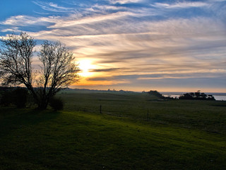 Fototapeta na wymiar Landscape of green fields and a dramatic sunset