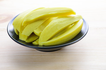 Preserved mango fruits in black bowl