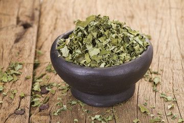 Dust and moringa leaves on wooden background
