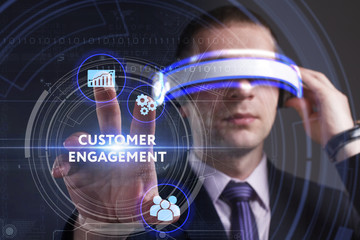 Business, Technology, Internet and network concept. Young businessman working in virtual reality glasses sees the inscription: Customer engagement
