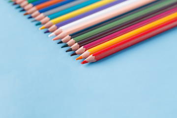 Full row of multycolor pencils on blue background