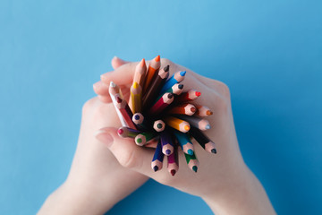 Hands full of bunch colored pencils
