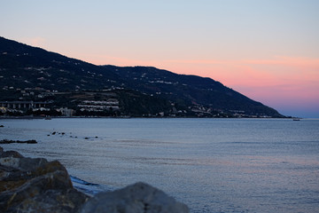 Sunset at the Tyrrhenian Sea. Houses are located on a hillside mountain