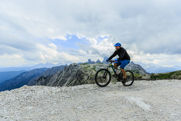 View of cyclist riding mountain bike on trail in Dolomites,Tre Cime di Laverado, South Tirol, Italy