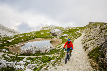 Fototapeta na wymiar View of cyclist riding mountain bike on trail in Dolomites,Tre Cime di Laverado, South Tirol, Italy