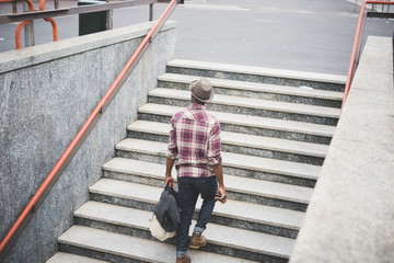Rear view of young man walking up steps in city
