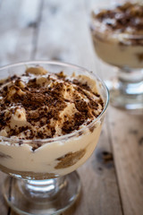 Tiramisu in glass. Italian dessert. Beautiful wooden background.