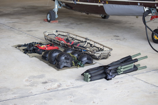 searh and rescue equipment arrange on ground before mission with helicopter background