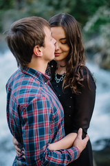 Fototapeta premium pair of beautiful brunette with a guy hugging on the nature