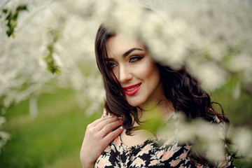 Spring girl.Beautiful model with flower wreath on her head.Close up portrait of romantic sensual brunette lady with blue eyes and long shiny hair.Dreaming princess in lacy dress looking afar.