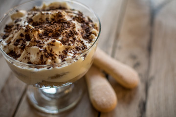 Tiramisu in glass. Italian dessert. Beautiful wooden background.