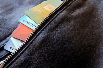 Credit cards peeking out of the black leather bag, close-up. Horizontal background with copy space.