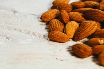 handful of almonds on a white wooden background