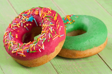 two glazed donut on wooden green background