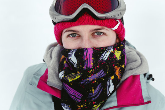Portrait of young woman in red hat, ski glasses and warm jacket
