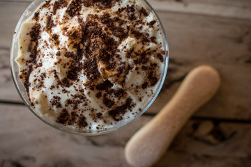 Tiramisu in glass. Italian dessert. Beautiful wooden background.