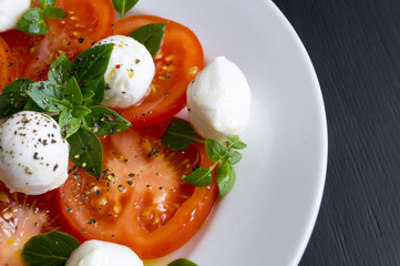 Caprese salad with ripe tomatoes and mozzarella with fresh Basil leaves. Italian food.