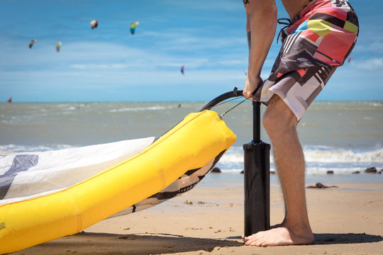 Kitesurfer on beach inflating kite