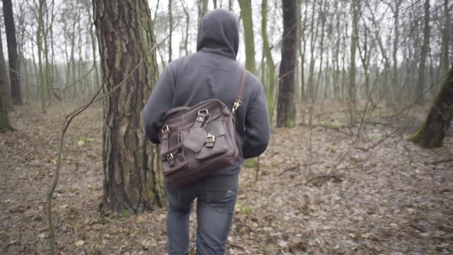 Sad man walking by forest