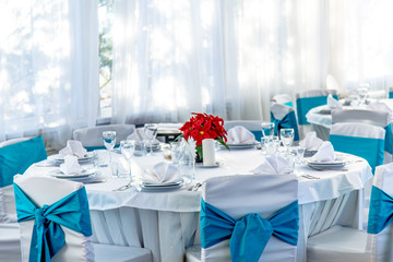 Round white table with a tablecloth set for dinner in a country restaurant.