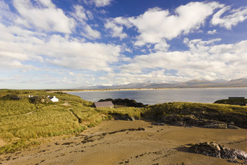 Fototapeta na wymiar Scenic view eastwards across Llanddwyn Island & Llanddwyn Bay towards the Snowdonia Mountain range, Isle of Anglesey, North Wales