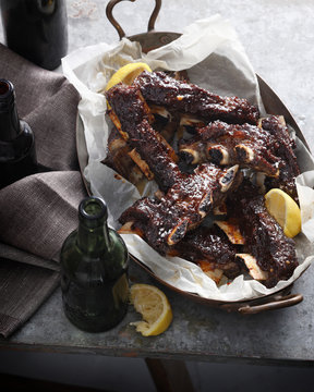 Ribs with barbecue sauce and lemon in dish