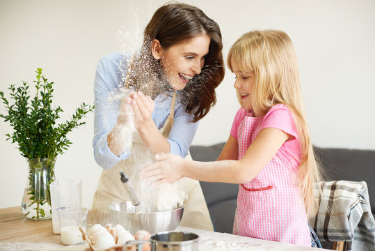 Mother and daughter baking together, fooling around
