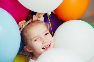 Obraz premium Happy little girl playing with balloons